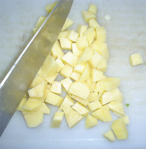 cortamos papas en cuadraditos para luego hervir sacando las papas un poco antes del tiempo de cocción
