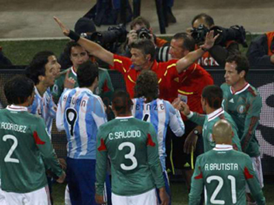 Los jugadores argentinos y méxicanos se quejan ante el árbitro Rosetti luego del polémico gol de Tévez