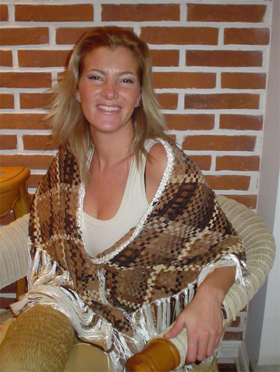 Poncho de gamuza tejido puesto con pantalón color beige y botas de cuero marrón