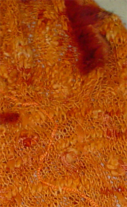 Poncho tejido naranja con apliques en piel
